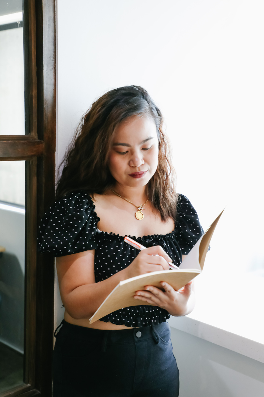 Woman writing in notebook in the office